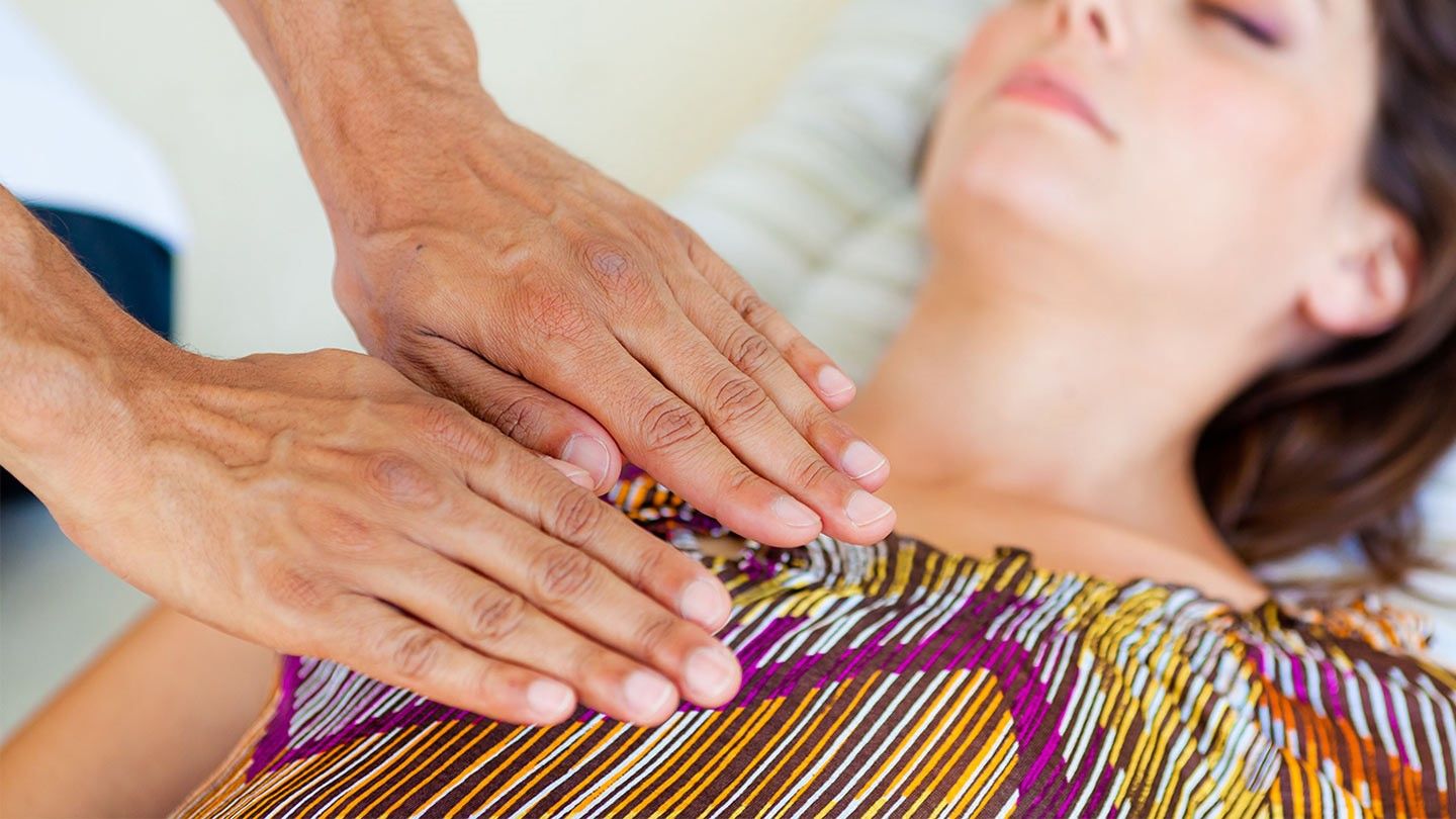 a woman with MS receiving Reiki treatment